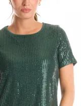 Blusa de manga corta con cuello redondo, confeccionada en tejido cubierto de lentejuelas color verde esmeralda. Cuenta con forro interno a tono y un corte recto.