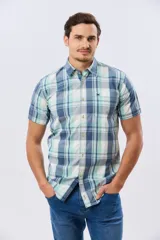 Camisa de manga corta con estampado de cuadros en tonos celestes, azules, blancos y verdes, con cierre frontal de botones y bolsillo ojal en el pecho.