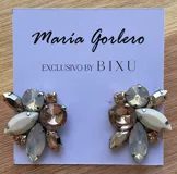 Par de caravanas con forma de flor, con cristales facetados en tonos lila, blanco y dorado.