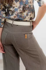 Pantalón de corte wide leg color marrón, con tiro medio, costuras a contratono y cierre frontal con botón metálico.