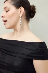 Top negro con escote off-shoulder, de tejido de punto con efecto satinado y corte ajustado.