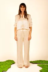 Pantalón de satén color beige con estampado de leopardo, corte palazzo y cintura con cordón ajustable.