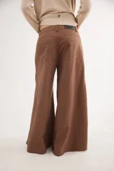 Pantalón de tiro medio con diseño de pierna ancha y cortes curvos que aportan movimiento. Presenta cintura ajustada, bolsillos delanteros y bolsillos plaque en la parte trasera.