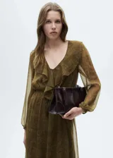 Vestido largo de tejido fluido semitransparente con estampado paisley en tonos verdes y marrones. Presenta cuello en pico con detalle de volantes, mangas largas con puños elásticos y cintura ajustable con cordón. Incluye forro interior y diseño evasé con bajo con vuelo.