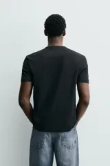 Camiseta blanca de manga corta con cuello redondo y tapeta de botones frontal (cuello panadero o henley).