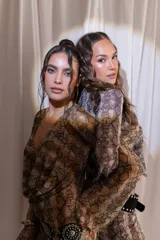 Vestido corto confeccionado en tul y lycra con estampado animal print de serpiente, escote en V pronunciado y mangas largas con diseño acampanado.