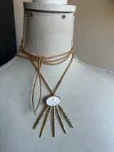 Collar con tiento de gamuza color camel y dije con base de bronce labrado y centro de nácar.