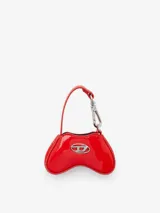 Minibolso charm Diesel Play con diseño inspirado en un control de videojuegos, confeccionado en material de acabado brillante color rojo. Presenta el icónico logo metálico Oval D en el frente y un gancho superior tipo llavero con correa.