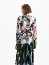 Camisa de satén con estampado multicolor, cuello camisero, mangas largas y puños con botones dorados. Cierre frontal oculto y lazos en la cintura para ajustar la silueta.
