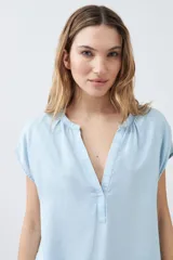 Blusa celeste de lyocell con escote en V y mangas cortas.