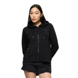 Campera con capucha Merrell modelo Farah, de color negro, confeccionada en suave tejido polar cepillado. Cuenta con cierre frontal de cremallera, cordones ajustables en la capucha y el logo de la marca estampado en el pecho.