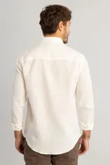 Camisa de manga larga confeccionada en lino puro, color off white. Presenta cuello clásico, cierre frontal con botones y corte regular con caída natural.