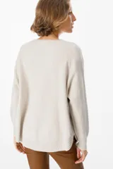 Sweater de punto fino color azul, con silueta holgada, cuello a la base y mangas tipo murciélago.