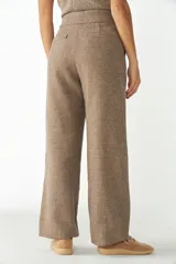 Pantalón de tiro alto y pierna recta color marrón, con bolsillos laterales y presillas para cinto.