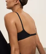 Top deportivo negro, tipo bralette, con escote en V y tirantes finos ajustables.