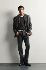 Blazer de cuero marrón oscuro, de corte regular fit, con solapas de muesca, cierre frontal de tres botones y bolsillos con solapa en la cadera.