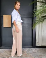 Pantalón de corte amplio y tiro medio, confeccionado en terciopelo color beige. Presenta cintura elástica con cordón ajustable y bolsillos laterales.