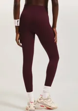 Calza deportiva de tiro alto con textura acanalada, confeccionada en tejido elástico de color verde oscuro.