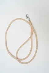 Correa de cuello tipo lanyard en color dorado, confeccionada en malla tubular con acabado brillante y cierre de mosquetón metálico plateado.