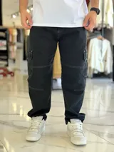 Pantalón cargo de jean azul con múltiples bolsillos en los laterales y diseño holgado.