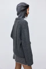 Buzo de punto suave con cuello redondo acanalado, diseño de hombros caídos y terminaciones acanaladas en puños y bajo.