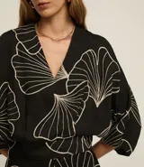 Blusa negra con estampado de hojas en color crema, escote en V y mangas 7/8.