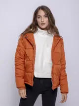 Campera puffer verde oliva de nylon con capucha forrada en corderito. Tiene cierre frontal con cremallera y botones a presión, y dos bolsillos laterales con cremallera.