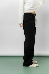 Pantalón de corte relajado y pierna recta, confeccionado en tejido tipo corderoy liviano. Presenta cintura elastizada con cordón ajustable y diseño de silueta amplia.