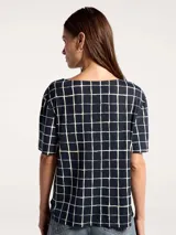 Blusa de cuello en V con estampado geométrico de líneas blancas sobre fondo azul marino.