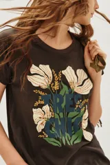 Remera de algodón color marrón oscuro con cuello redondo y manga corta. Estampado frontal con flores blancas y detalles en lentejuelas doradas, hojas verdes y texto en azul oscuro que dice "TRÈS CHIC".