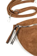 Bandolera tipo riñonera de gamuza color marrón, con cierre principal plateado y tiradores largos. Incluye correa regulable desmontable.