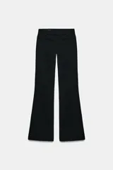 Pantalón de tiro medio con corte flare, cierre frontal con cremallera, botón interior y ganchos metálicos, con falsos bolsillos de vivo en el delantero.