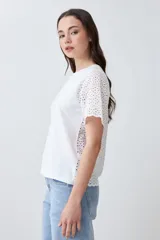 Remera fucsia de manga corta con detalle de broderie en las mangas.