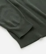 Suéter de punto con cuello redondo y manga larga, diseñado con un patrón de bloques de color en tonos beige, blanco y gris. Presenta un corte regular que se ajusta de forma anatómica al cuerpo.