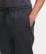 Pantalón deportivo de corte jogger, color negro, con cintura elástica ajustable mediante cordón, bolsillos laterales y puños acanalados en los tobillos. Confeccionado en tejido de algodón con interior felpudo.