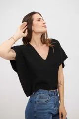 Chaleco de punto negro con cuello en V y mangas cortas, confeccionado en un tejido texturizado con sutil brillo.