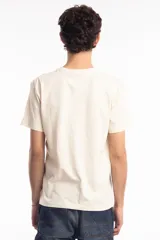 Remera unisex de corte holgado en color beige, con estampado gráfico en azul que incluye motivos japoneses y texto.