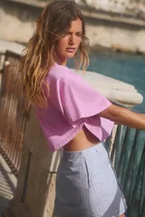 Camiseta gris con efecto lavado, cuello redondo con ribete y mangas cortas tipo capa.