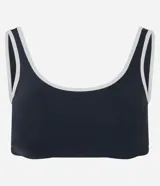 Top deportivo de microfibra con escote redondo delantero y escote en V en la espalda. Presenta un diseño bicolor con cuerpo en color crema y ribetes en color marrón oscuro, breteles anchos y copas desmontables.