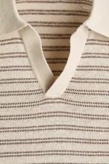 Polo en punto suave de mezcla de lino H&M, color beige con finas rayas horizontales marrones. Presenta cuello polo en pico de canalé y mangas cortas.