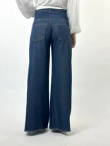 Pantalón de jean de tiro alto, corte palazzo y acabado laminado dorado.