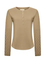 Remera de manga larga color beige con cuello redondo y cierre frontal parcial con botones. Presenta un diseño liso en el cuerpo y mangas con tejido texturizado en rombos.