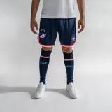Short de fútbol Umbro del Club Nacional de Football, modelo oficial 2024. Diseño en color azul marino con detalles en rojo y blanco en los bordes, escudo del club y logo de Umbro.