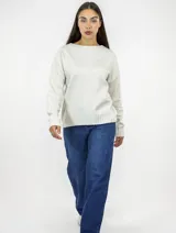 Buzo de punto color beige con cuello redondo y diseño de tejido liso. Presenta mangas largas con puños acanalados y ruedo también acanalado, ofreciendo un corte recto y holgado.