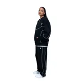 Campera deportiva unisex con cierre frontal completo, capucha con cordones ajustables y bolsillos laterales. Presenta un diseño en color negro con detalles de costuras en contraste color blanco que recorren el pecho, las mangas y los laterales.