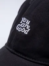 Gorro marrón de gabardina con visera y bordado frontal con la frase "You are Good" en color blanco.