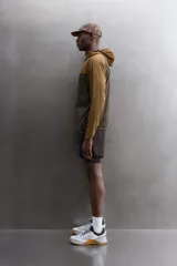 Chaqueta cortavientos Zara Athleticz de diseño bicolor en tonos marrón y tostado, con capucha, cierre frontal de cremallera y bolsillos funcionales.