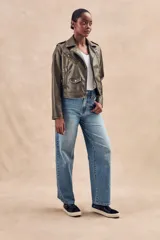 Campera corta color verde oliva de cuero sintético con cuello clásico, cierre frontal asimétrico con cremallera, bolsillos con cremallera y solapa, y detalles de costuras en los hombros.