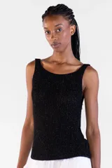 Musculosa de tejido de punto canalé con hilos metálicos Lurex que aportan brillo, color negro, escote bote y tir anchos.