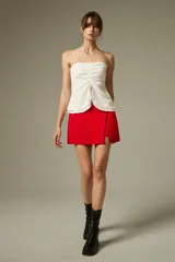 Falda mini de poliéster color rojo, de diseño recto con tajo y detalles de pinzas.